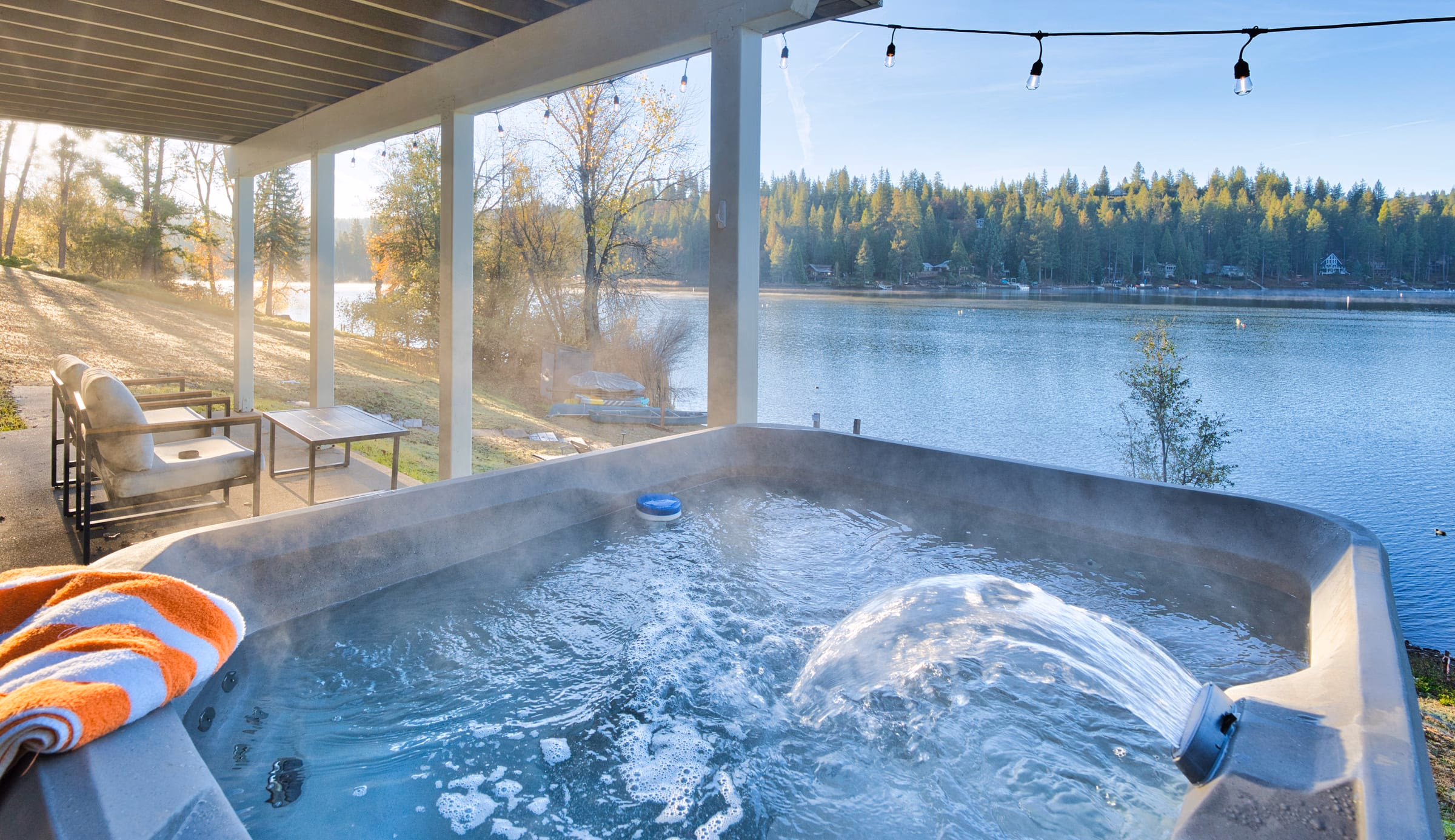 Bubbling hot tub under a covered patio with an unobstructed view across Pine Mountain Lake