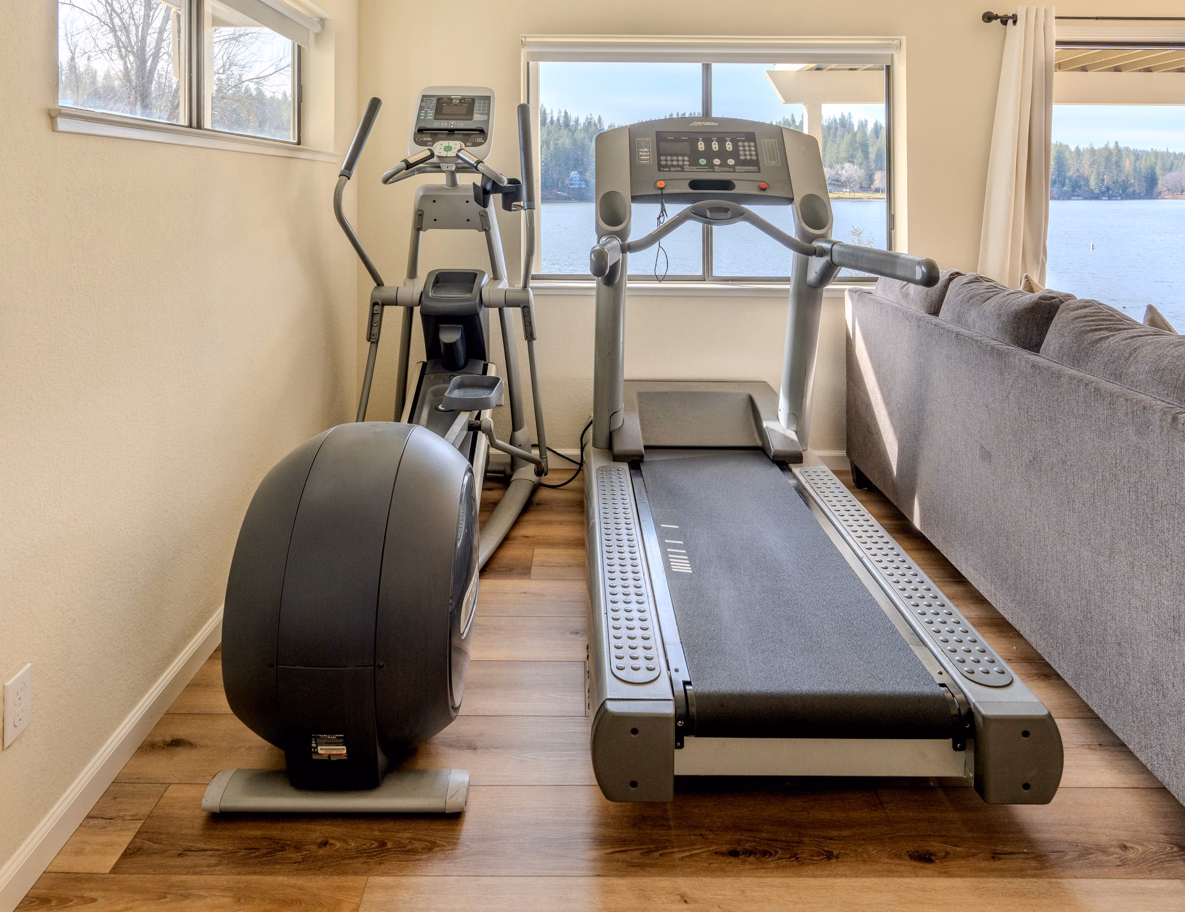Treadmill and elliptical machine positioned beside windows overlooking Pine Mountain Lake